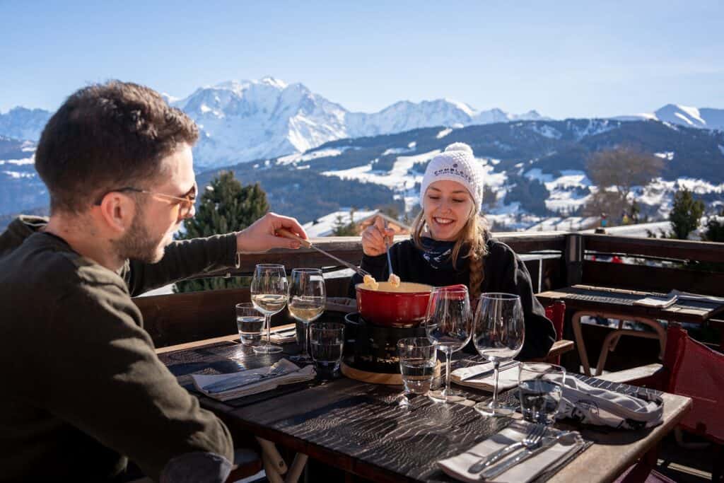 A couple enjoy a fondue at a mountain restaurant