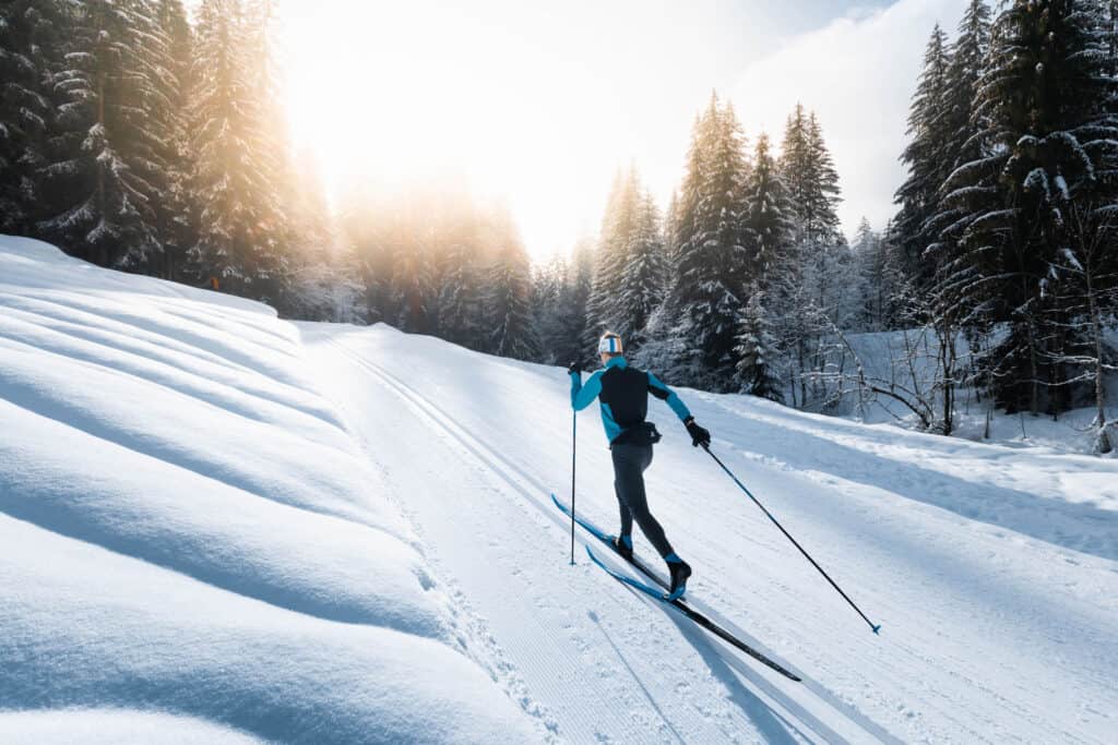 Homme sportif pratiquant le ski nordique en station dans les Alpes.