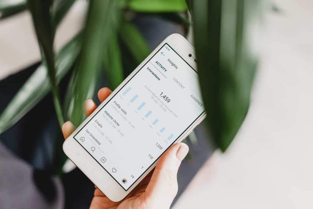 A person holds a phone reading Instagram insights