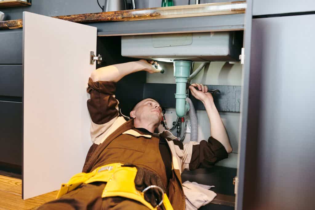 A plumber fixes a sink