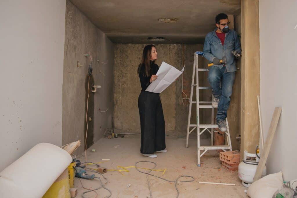 A woman reads a plan to a craftsman