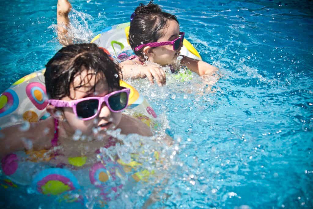 Two little girls swim in a pool