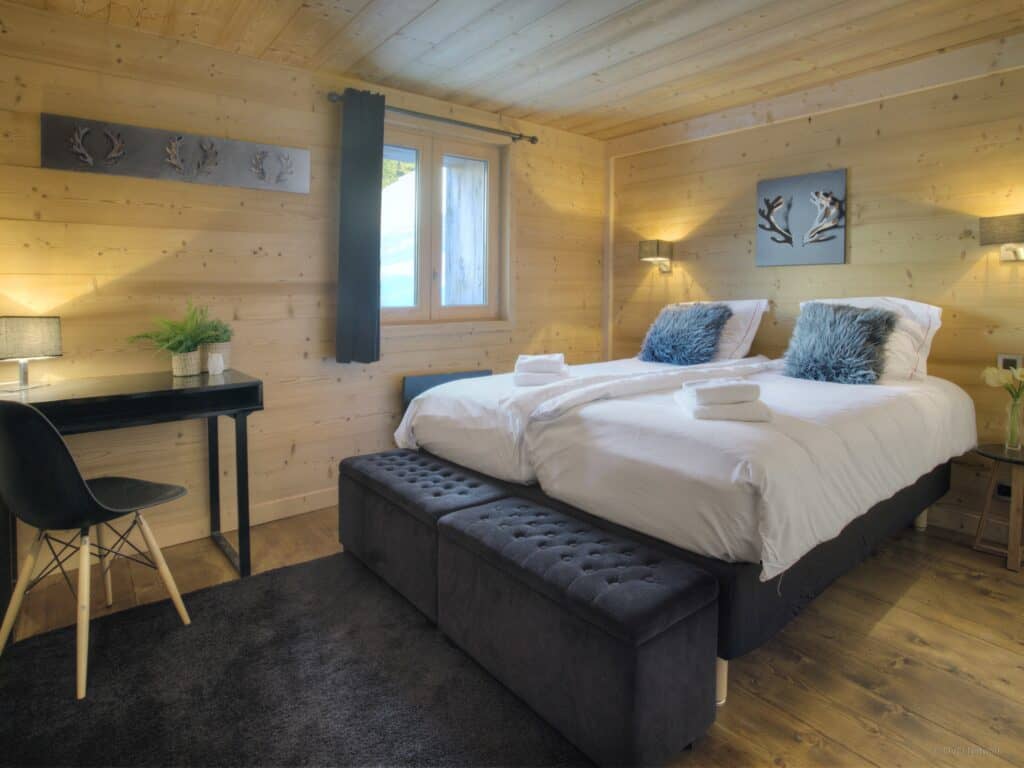 A double room with dark accents and a desk and chair