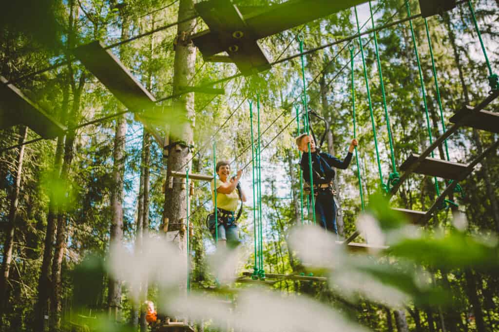 Mother and son climb a treetop adventures course