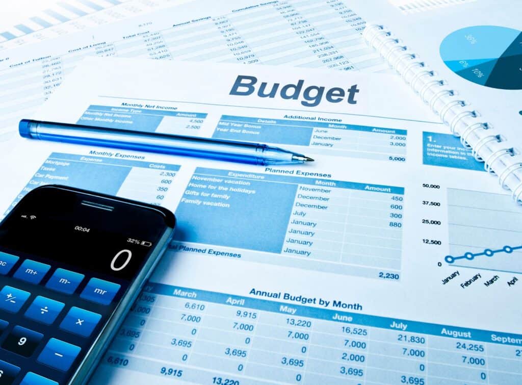 Document de suivi de budget, calculatrice et stylo.