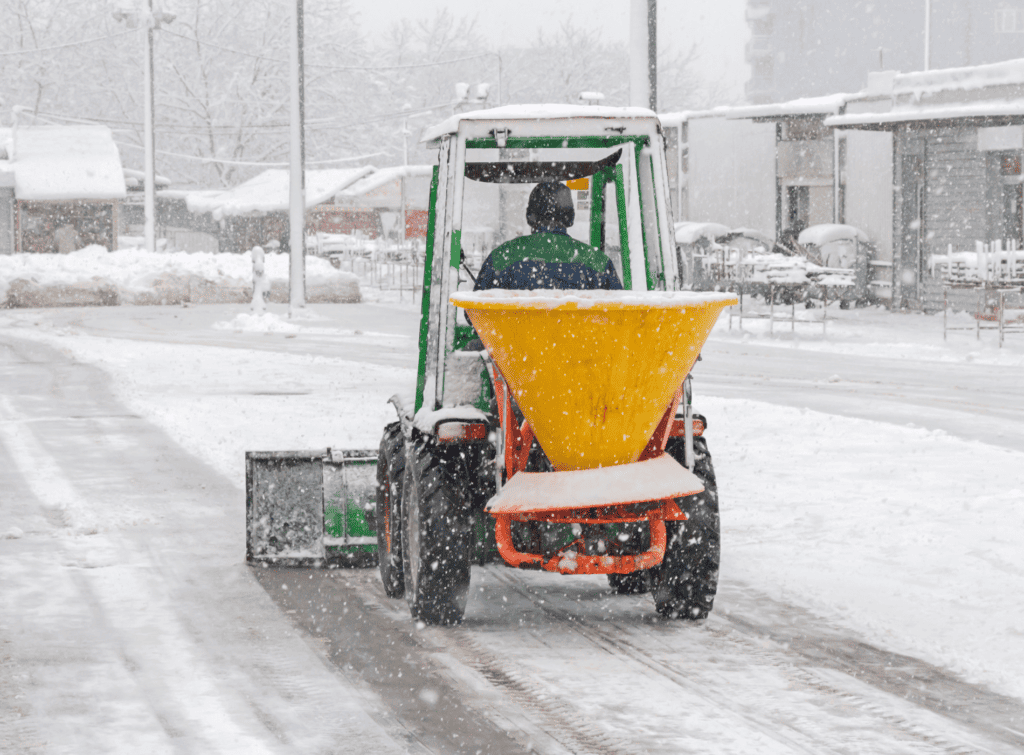 A person drives an individual snow plough away from the camera
