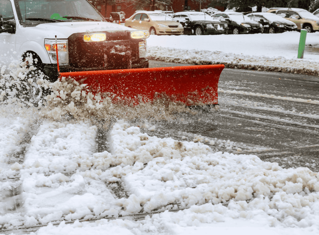 A snowplough attached to the front of a small truck