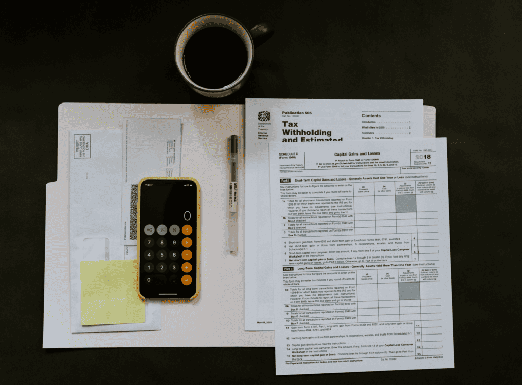 Dossier ouvert à plat sur un bureau noir, calculatrice et stylo.