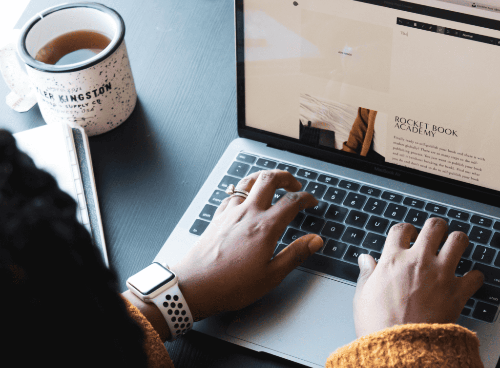 A woman types on her laptop keyboard