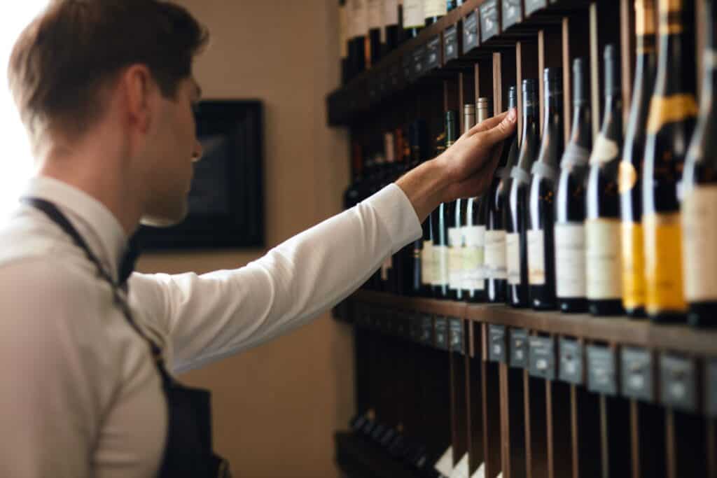 A man chooses wine off a shelf
