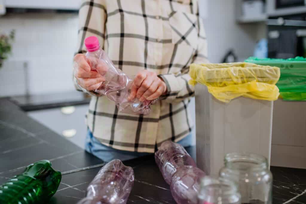 A woman sorts recycling at home