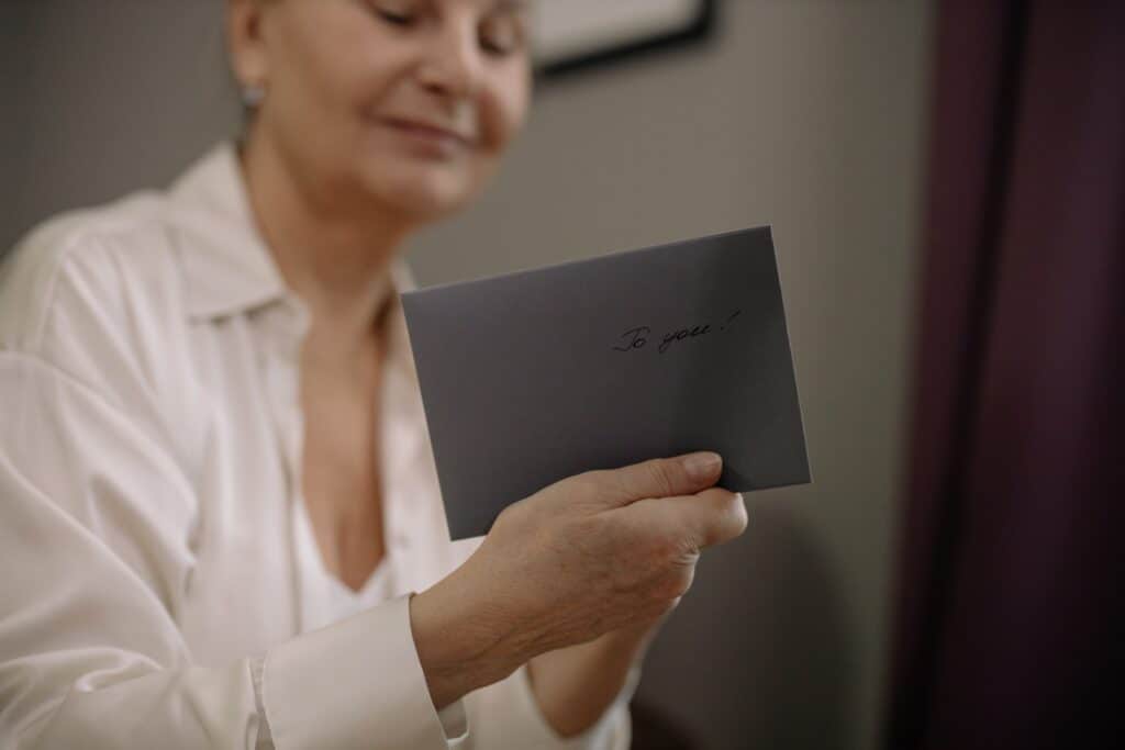 A woman holds a grey envelope