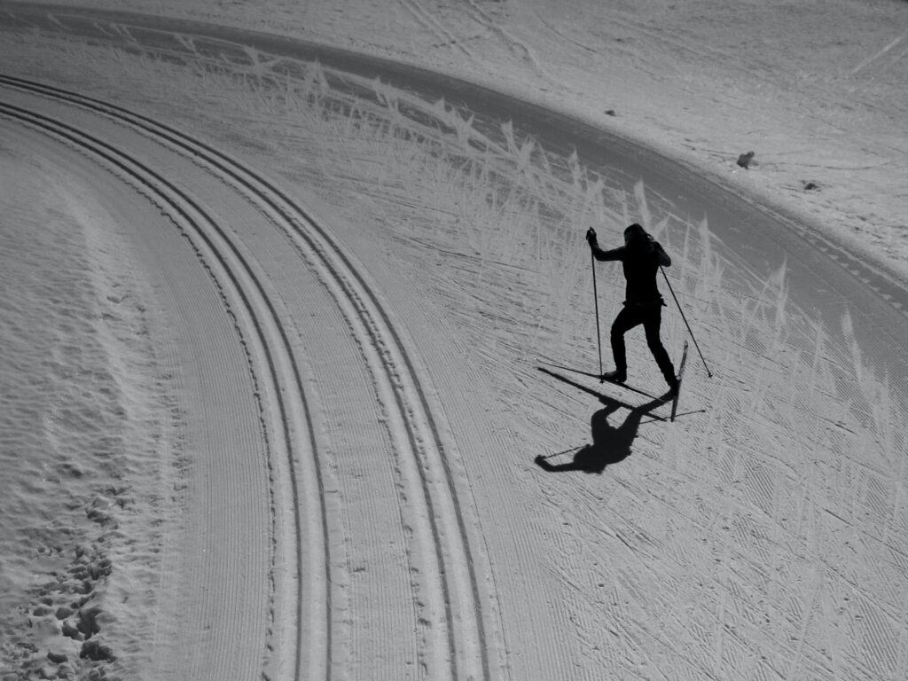 Black and white image of someone Nordic skiing