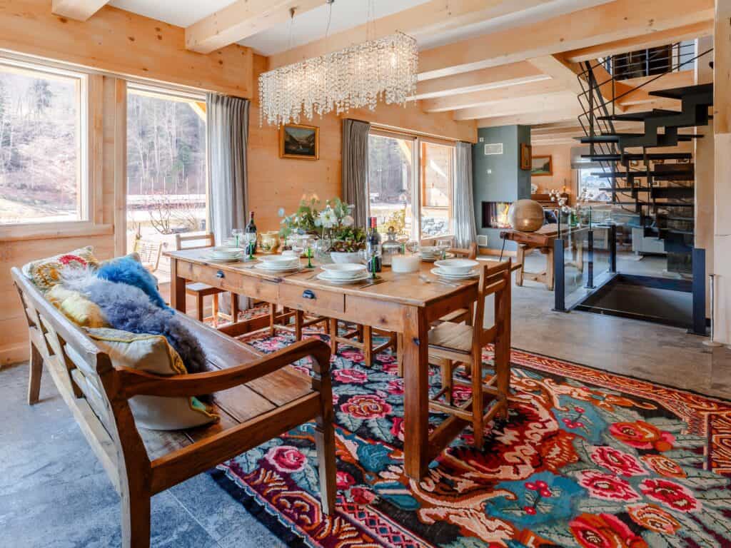 Le luxueux salon d'un chalet dans les Alpes, avec un grand tapis et une table pour 10.