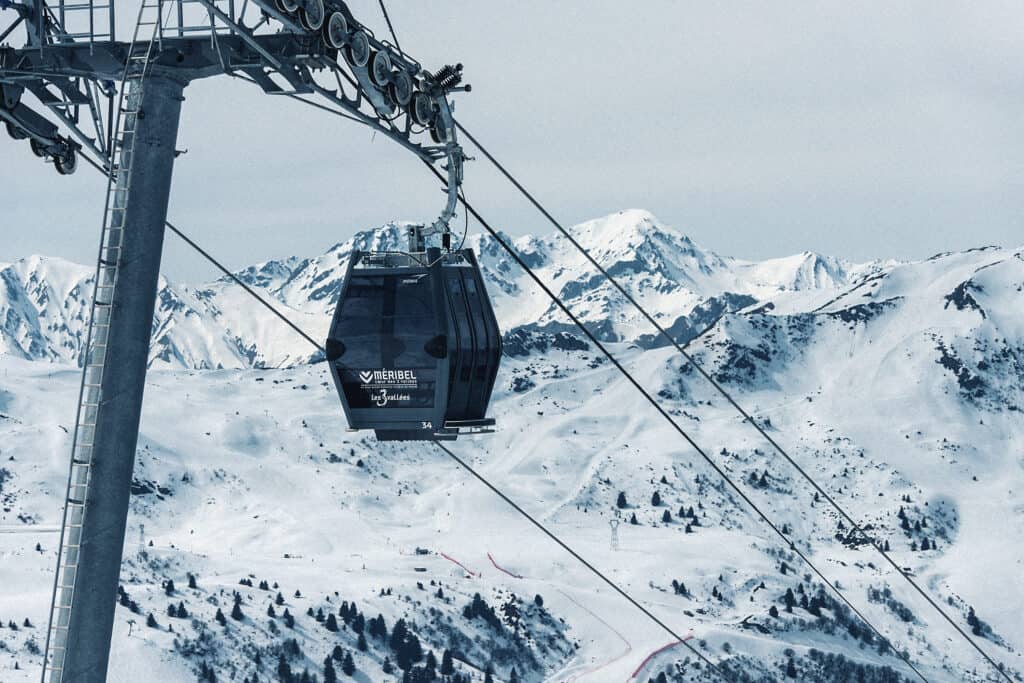 A cable car against snowy mountains