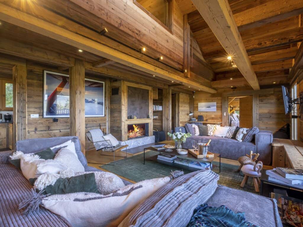 An alpine living room with grey sofas and a green rug