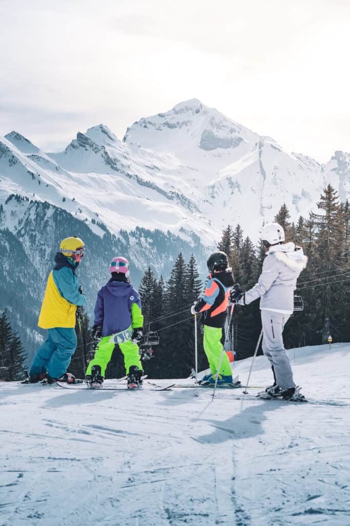 Famille de skieurs admirant les cimes enneigées à Manigod.