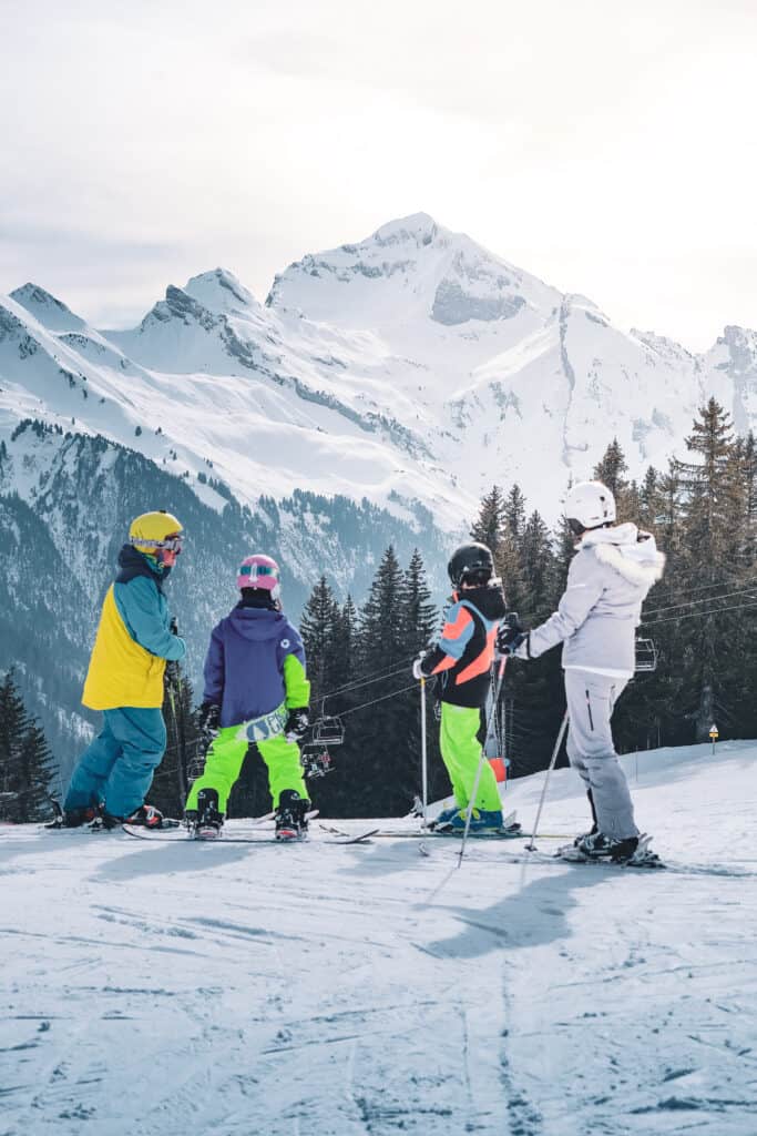 A family of skiers admiring the mountains in Manigod