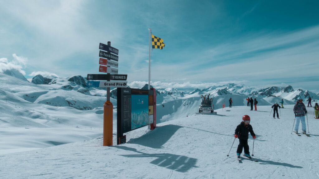 Des skieurs sur une piste plate, avec des panneaux de signalisation.