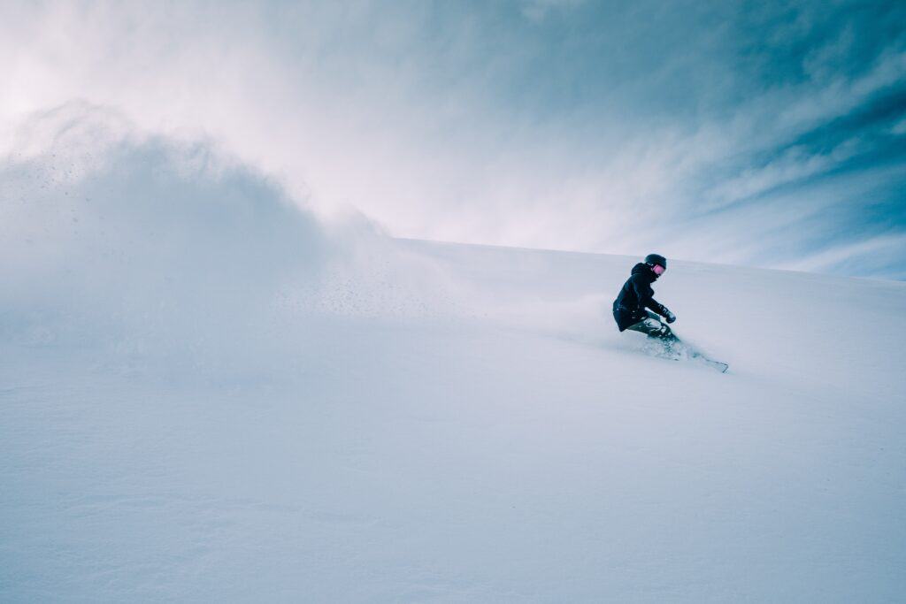 Un snowboarder traverse habilement la poudreuse.