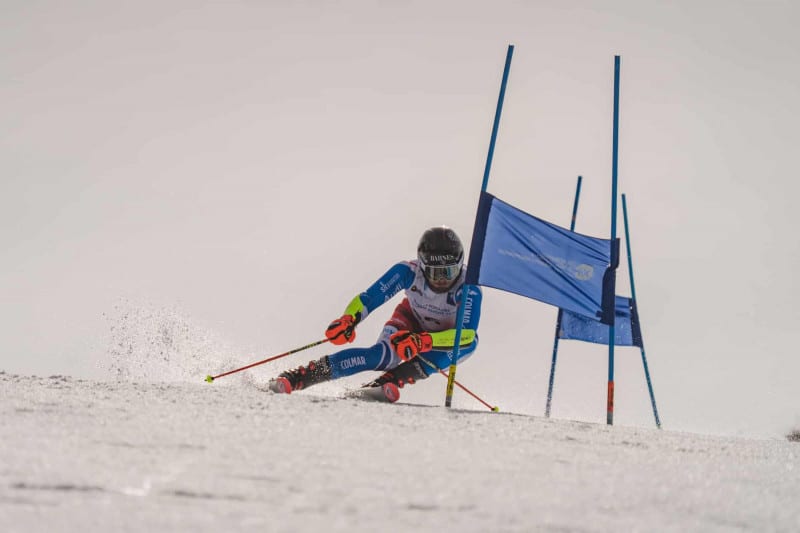 A young person races down a slalom track