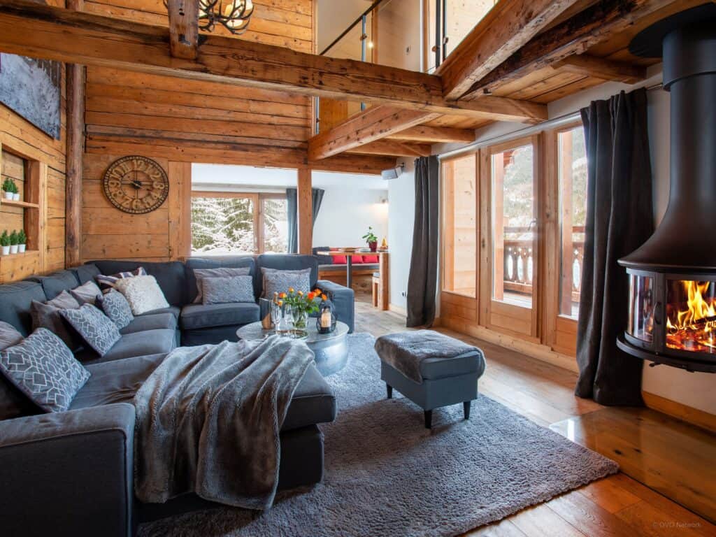 A large sofa in front of a suspended fireplace with views on to a balcony
