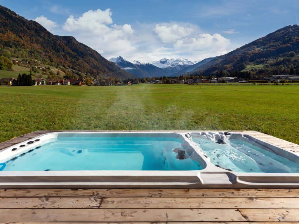 Jacuzzi avec vue sur un immense champs et des montagnes.