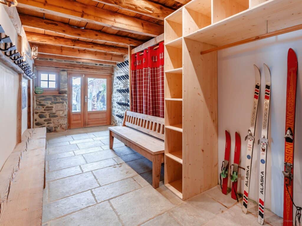 A ski room with a heated boot rack, shelving, coat hooks and benches