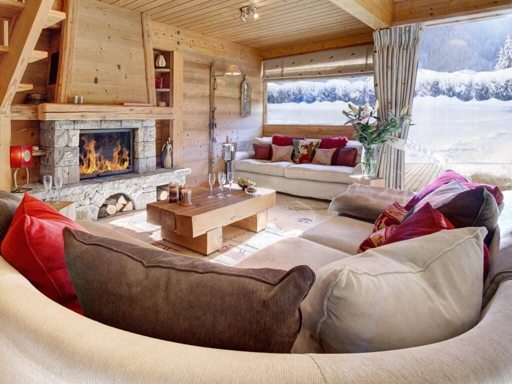 Salon avec cheminée et vue sur paysage enneigé.