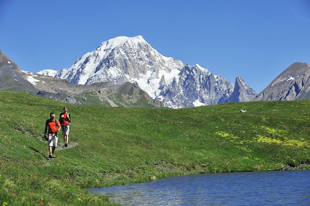 Randonneurs près d'un lac dans un paysage de montagnes.