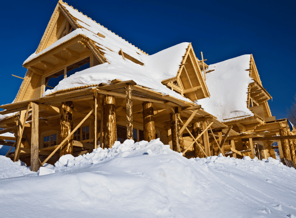 Chalet en construction recouvert de neige.