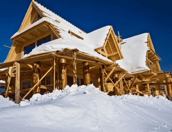 Chalet en construction recouvert de neige.