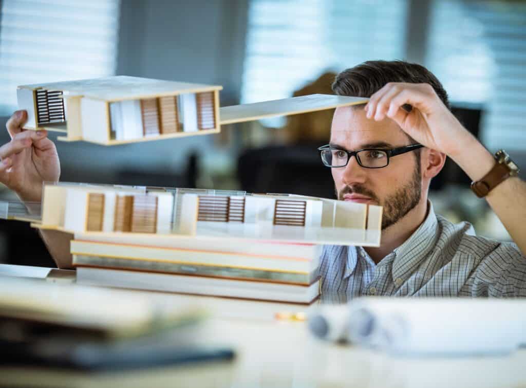 Homme assemblant une maquette 3D.