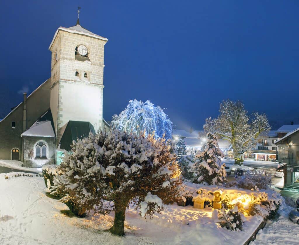 La place centrale de Samoëns enneigée avec son église et son gros tilleul.