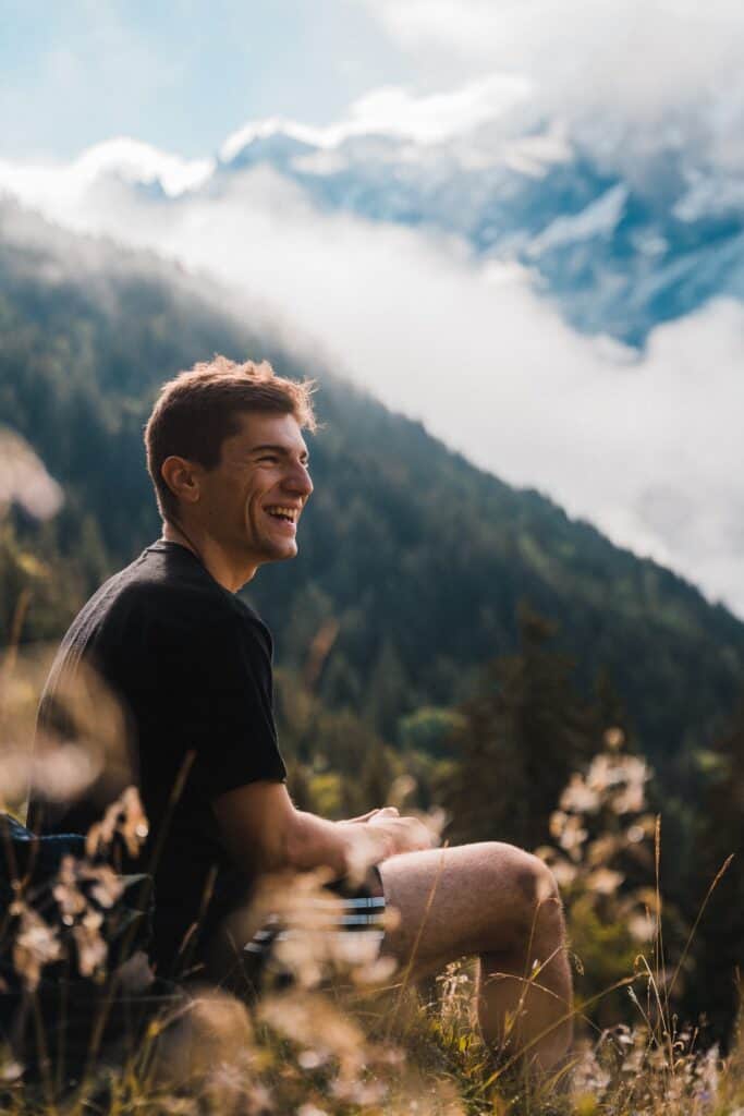 A man sits on the side of a mountain