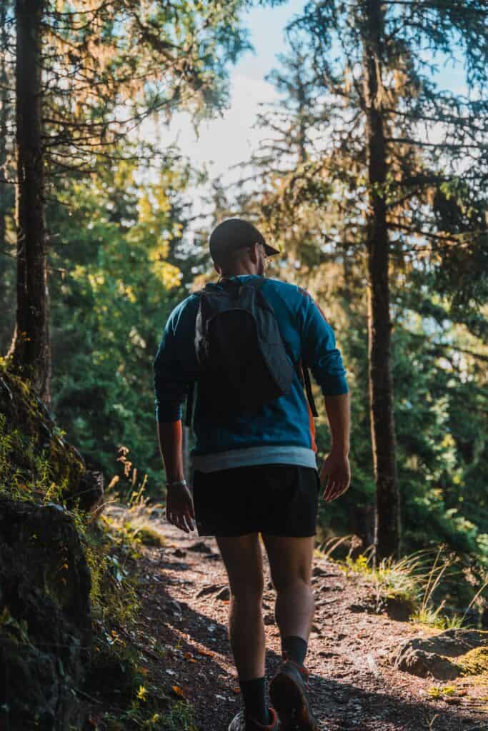 A man walks through a shaded forest