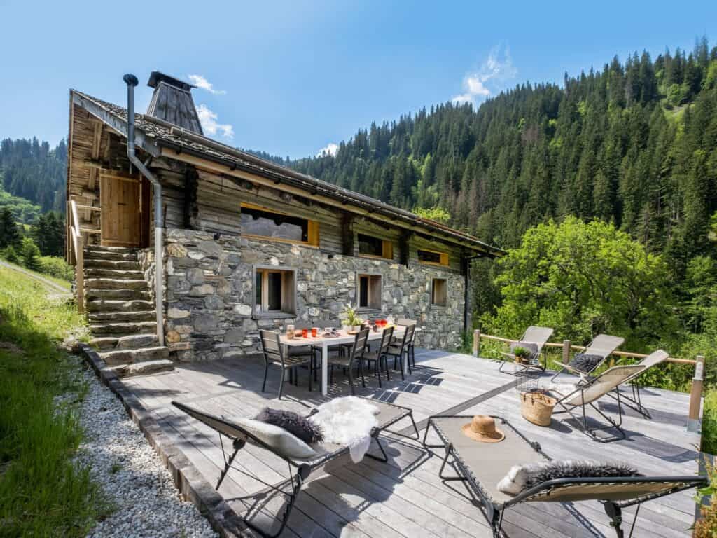 Stone chalet with a sunny terrace in summer.