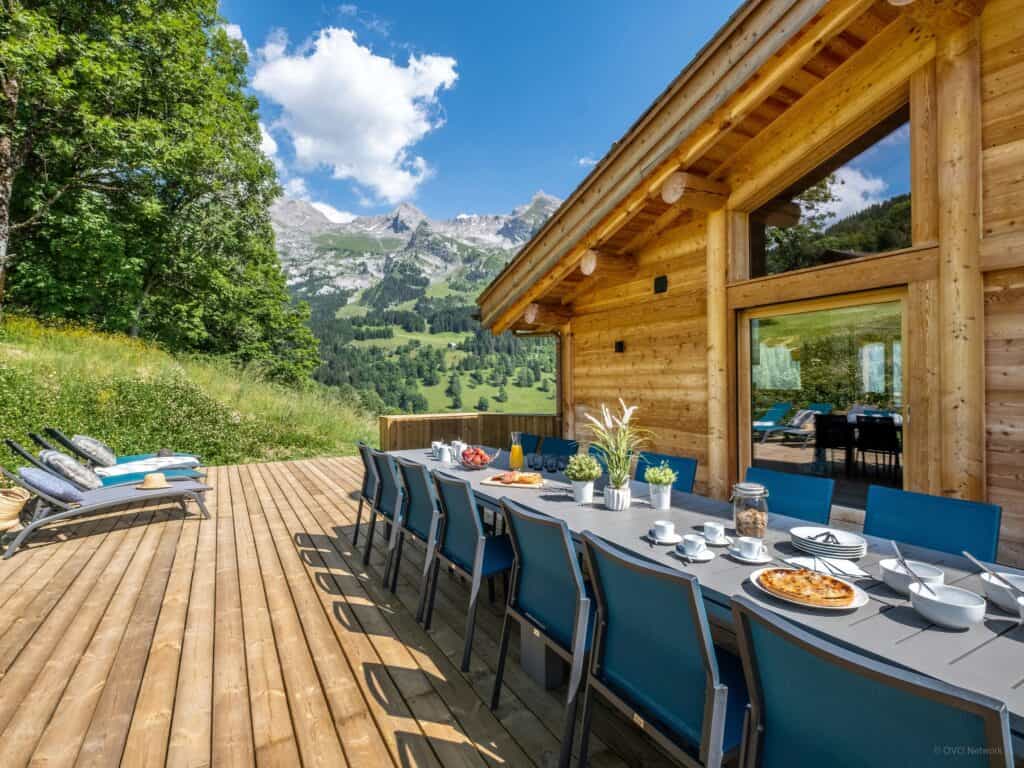 Terrasse ensoleillée du Chalet Bleu Infini avec table dressée.