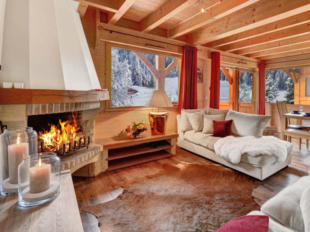 Salon de chalet avec cheminée allumée.