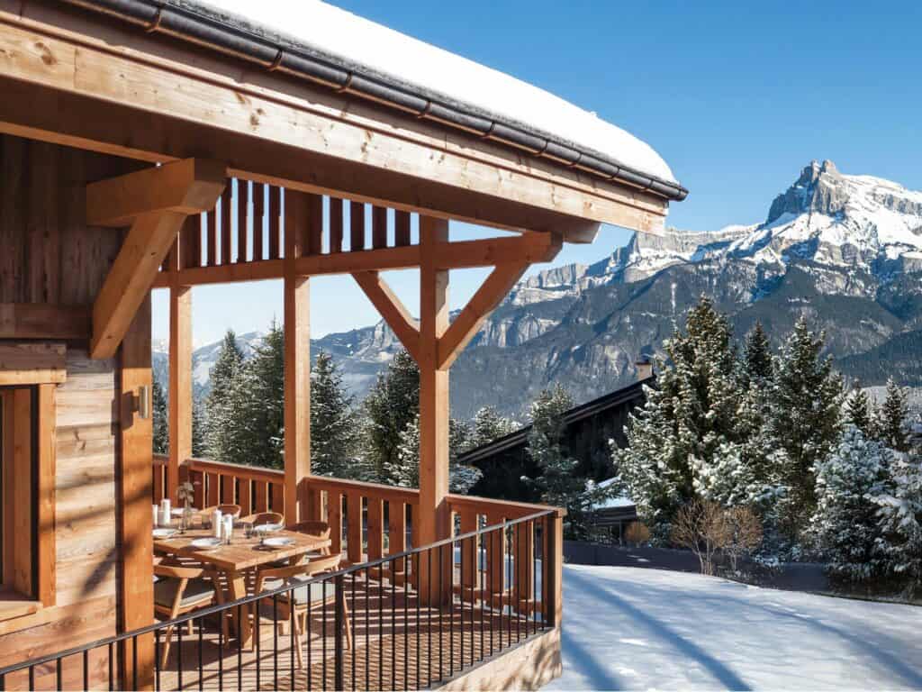 Dining table on a terrace with a view on a snowy mountain.