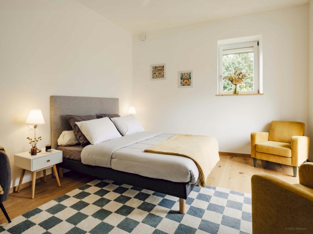 Chambre lumineuse de villa avec lit double.