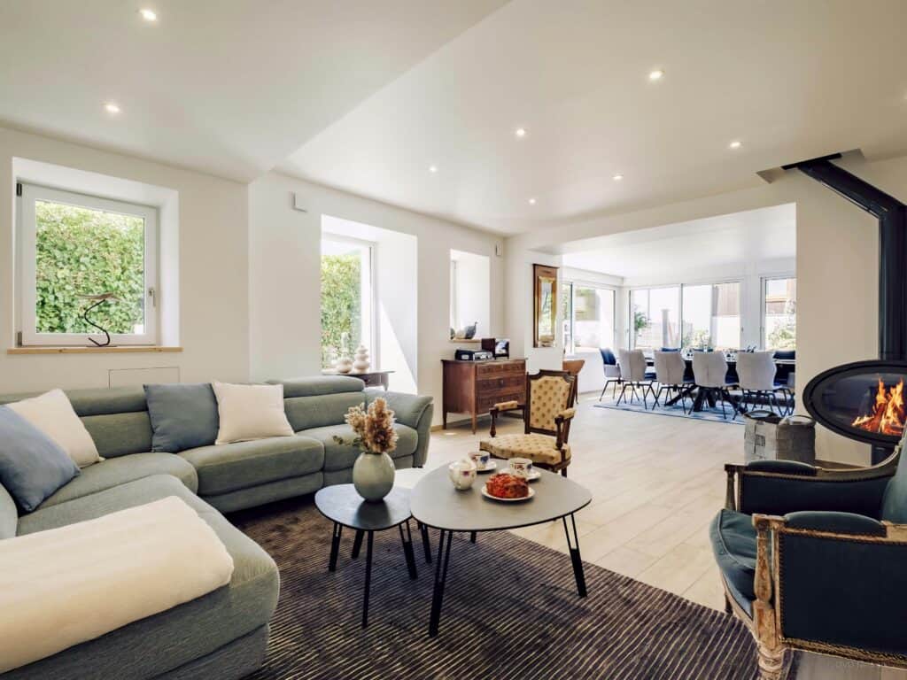 Bright villa living room with a lit up fireplace.