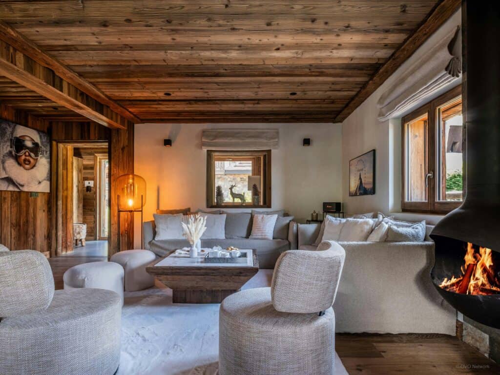 Salon de chalet confortable avec cheminée allumée.