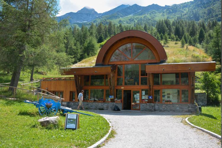 The Vanoise National Park Visitor Centre in summer, surrounded by pinetrees.